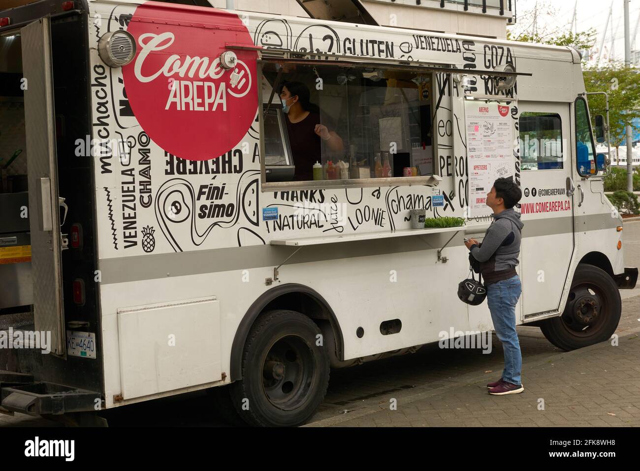 Woman ordering Venezuelan arepas from a food truck in Vancouver, British Columbia, Canada Stock Photo