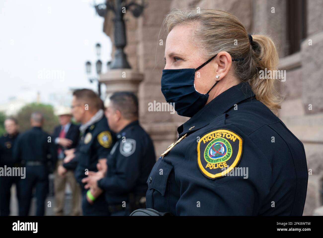 Austin, TX USA May 29, 2021: Jessica Anderson of the Houston Police Dept. listens as Texas police chiefs and commanders talk on the south steps of the Texas Capitol. The group opposes bills in the Senate that would allow anyone over 21 to publicly carry a handgun with no licensing or training requirement. Police leaders argue it will make their jobs harder as gun crimes are spiking statewide. Credit: Bob Daemmrich/Alamy Live News Stock Photo