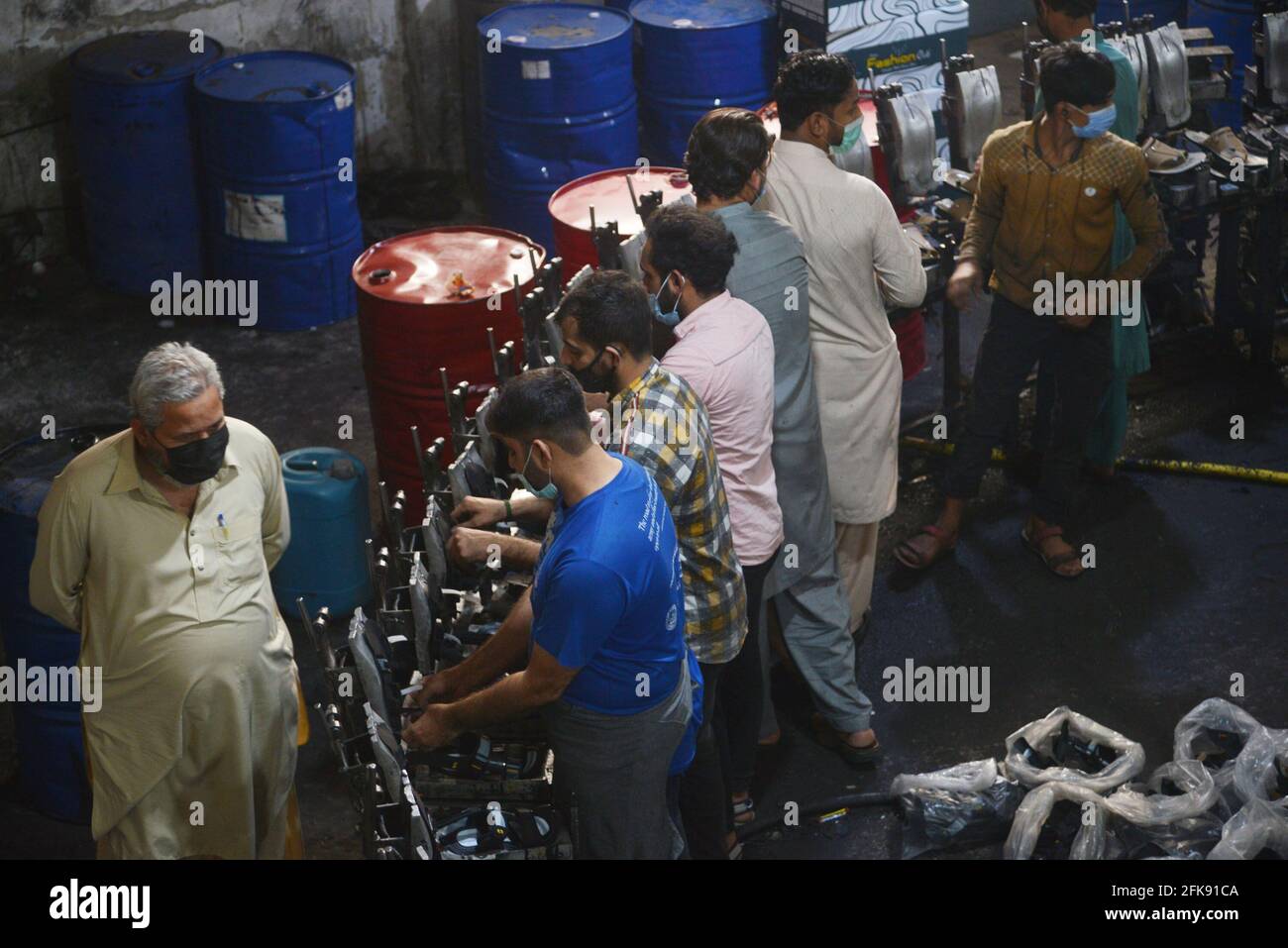 Lahore, Pakistan. 28th Apr, 2021. Pakistani workers busy in making shoes at shoes Factory in