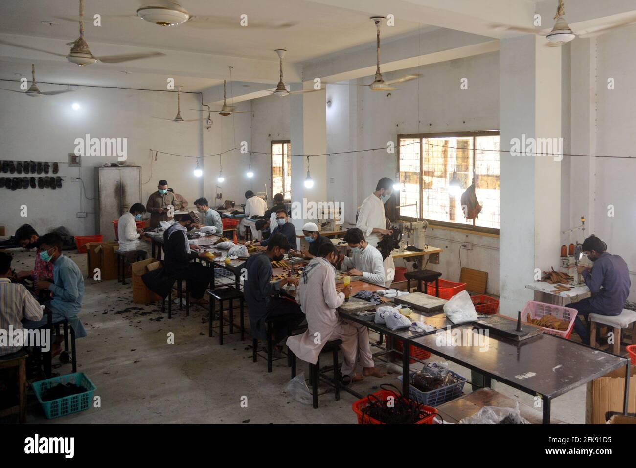 Lahore, Pakistan. 28th Apr, 2021. Pakistani workers busy in making shoes at shoes Factory in