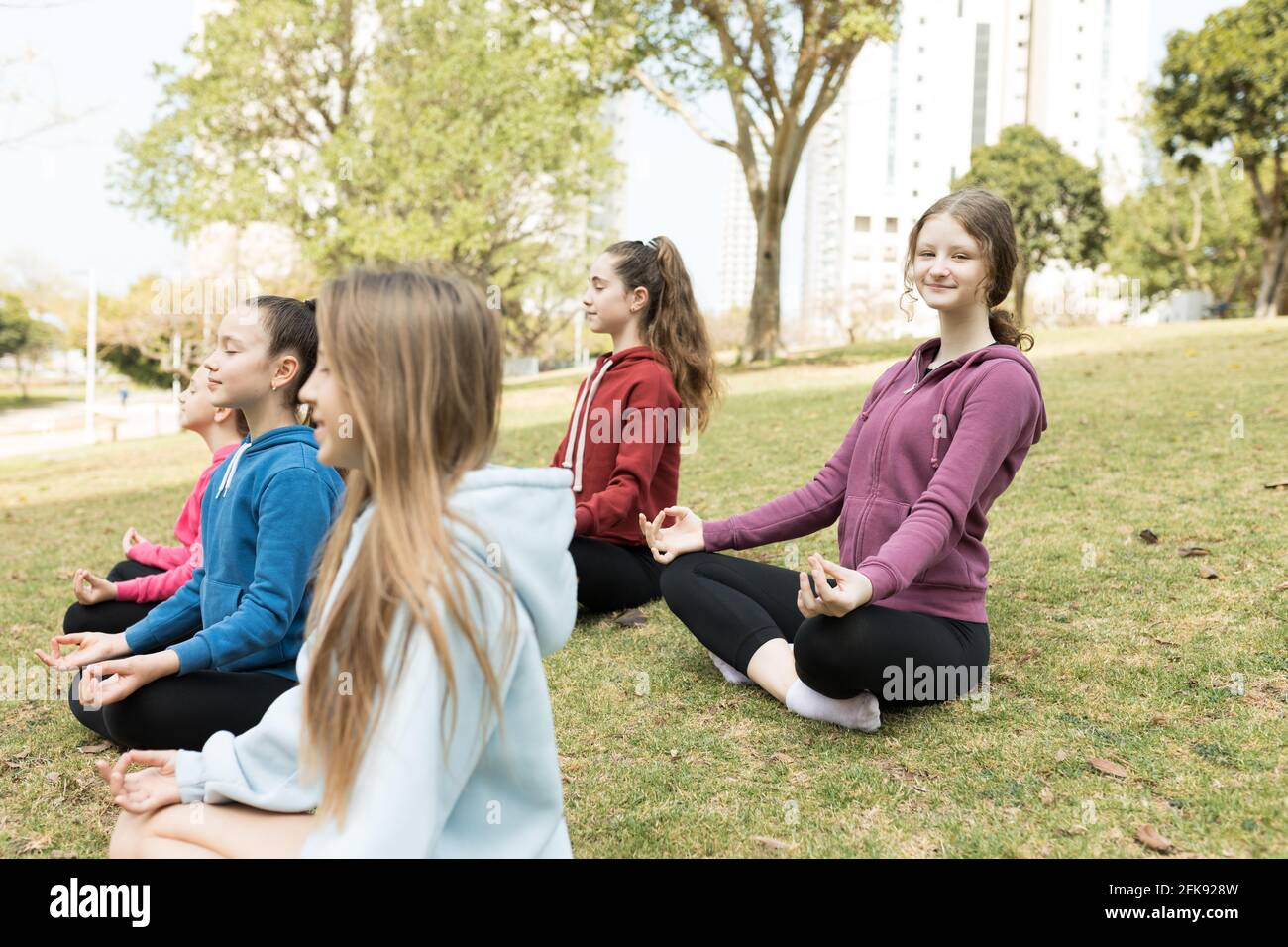Group of girls practicing yoga outside Stock Photo