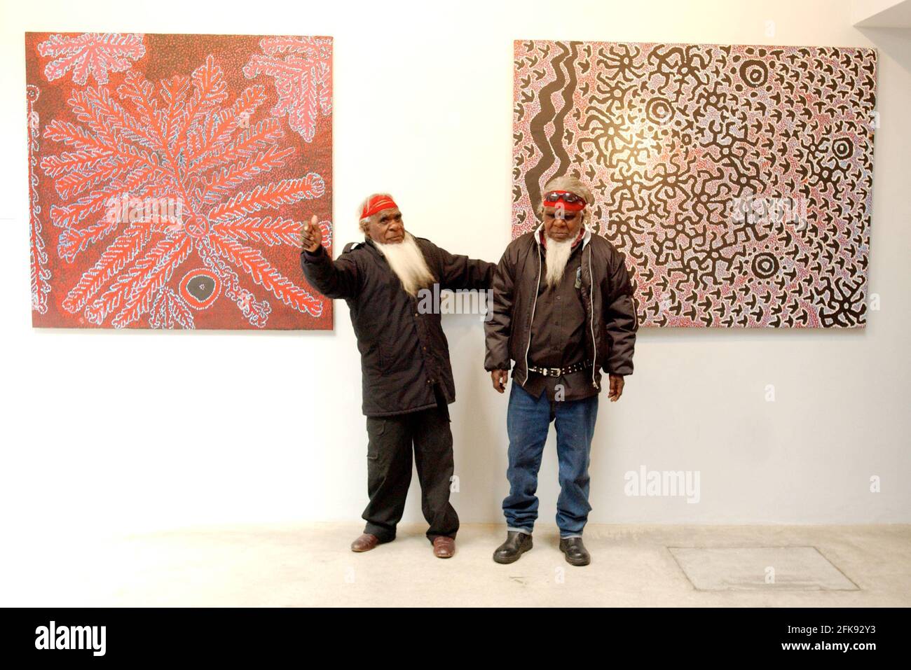 L-R SIMON HOGAN AND ROY UNDERWOOD OF THE SINIFEX PEOPLE IN AUSTRALIA IN FROUNT OF THEIR PAINTINGS WHICH DEPICT STORIES OF THE CREATION OF THE EMU,ON SHOW AT THE REBECCA HOSSACK GALLERY, LONDON W1. 10 May 2005 TOM PILSTON Stock Photo