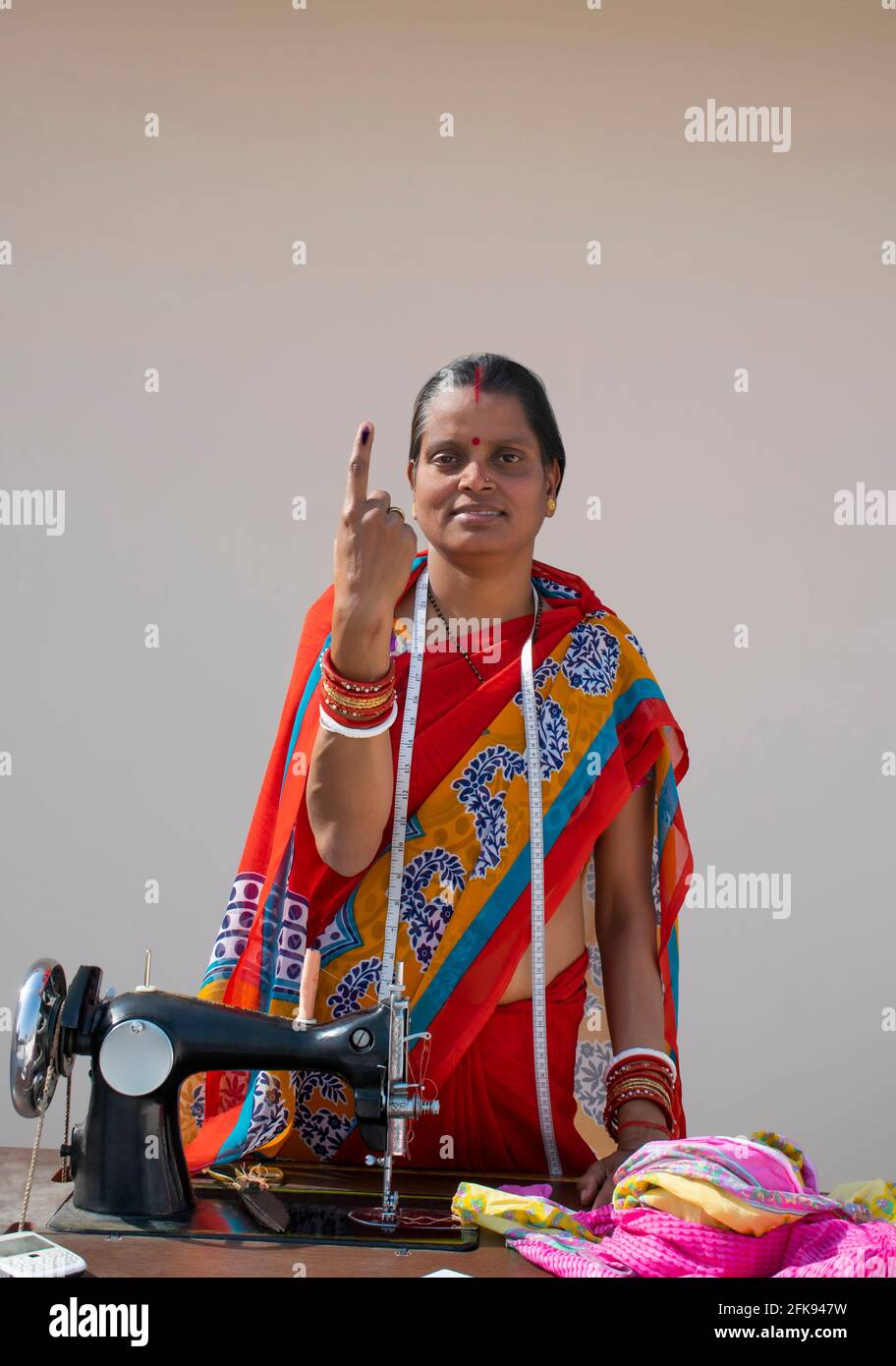 PORTRAIT OF A RURAL WOMAN voters mark on finger with sewing machine ...