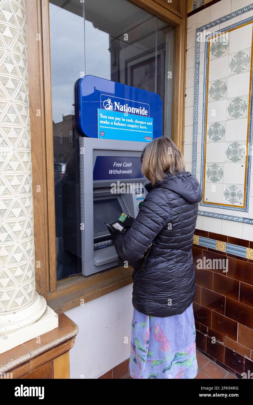 Nationwide ATM UK; a woman getting money from a Nationwide Bank cashpoint service, from her Flexaccount, Newmarket, Suffolk UK Stock Photo