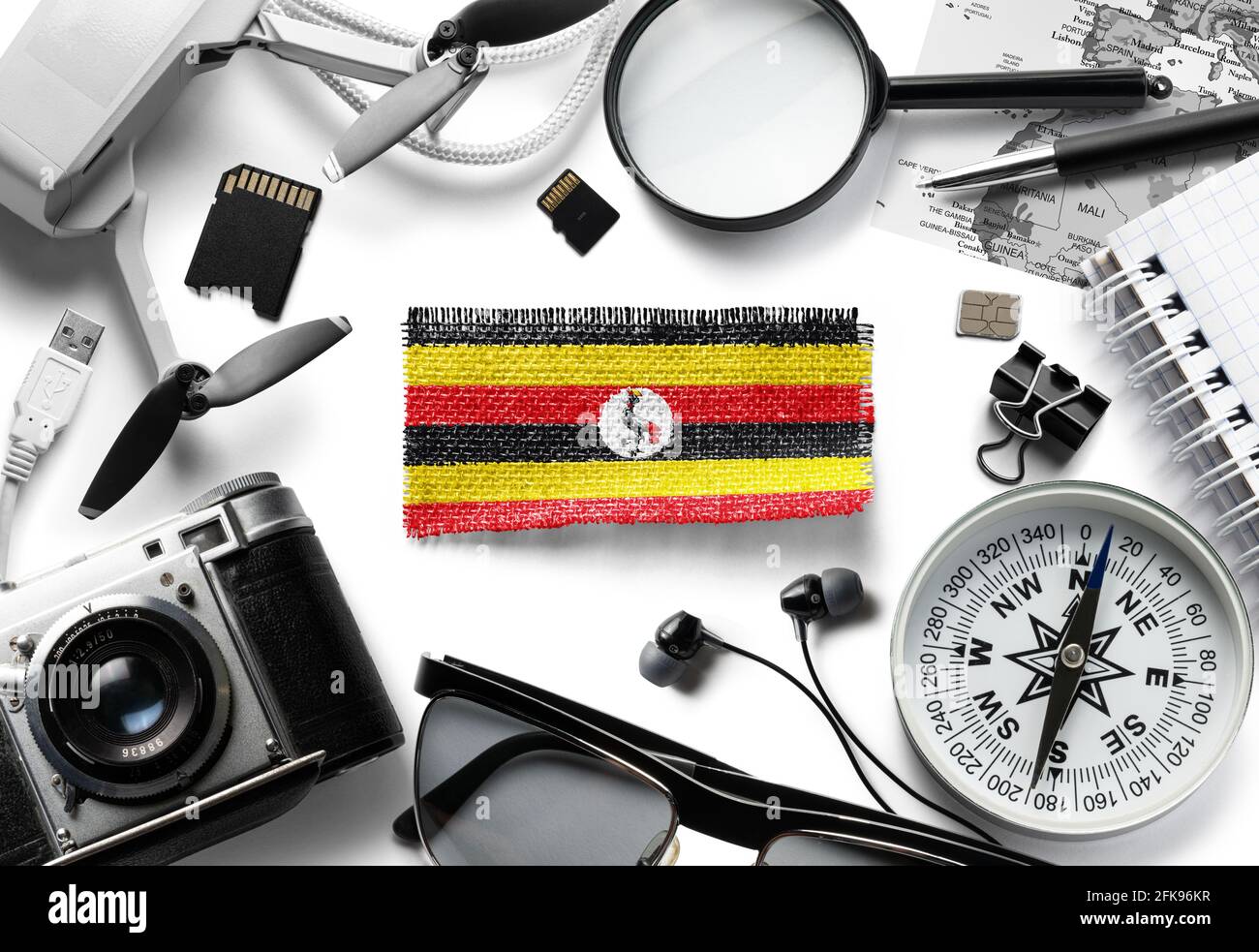 Flag of Uganda and travel accessories on a white background. Stock Photo