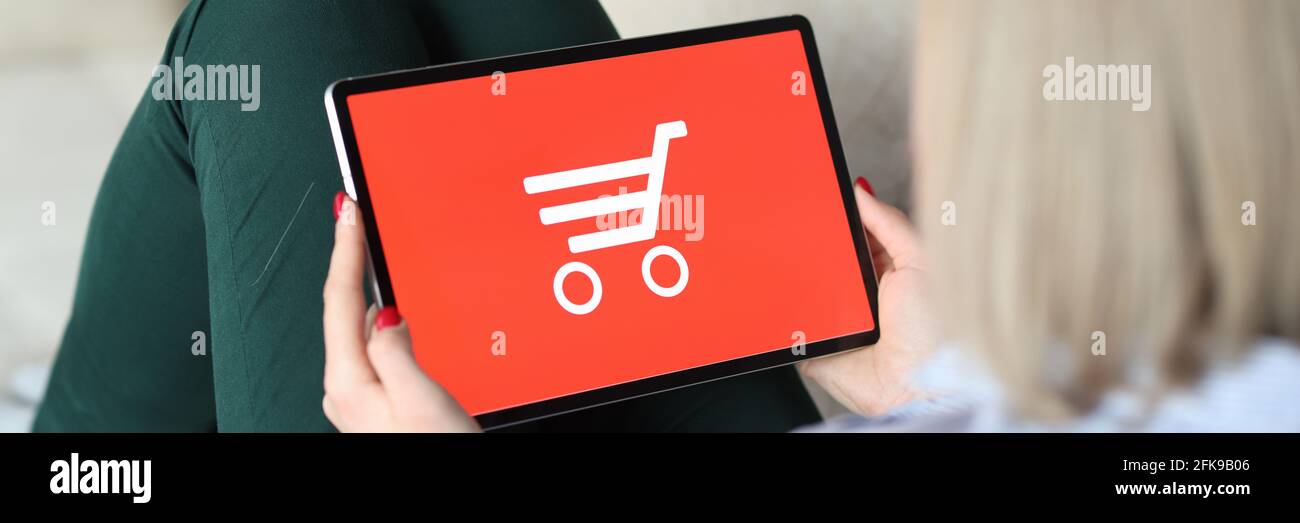 Woman siting on couch and holding tablet in her hands Stock Photo - Alamy