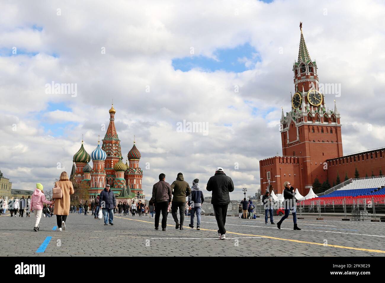 People walking on Red square on background of St. Basil's Cathedral and Kremlin tower. Tourists in city during covid-19 coronavirus pandemic Stock Photo