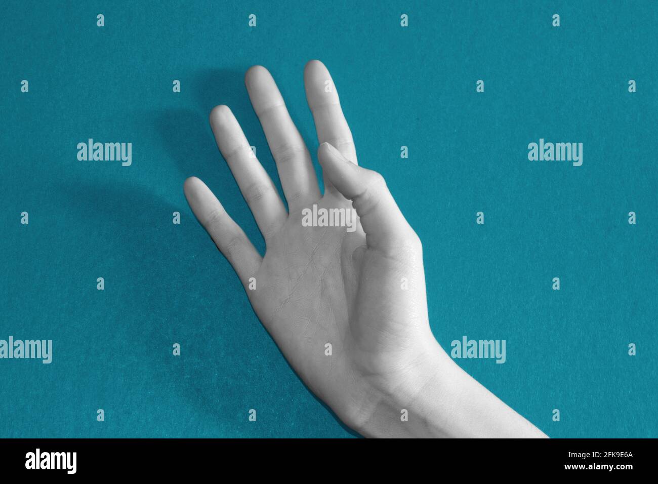 a black and white open hand on a blue background Stock Photo