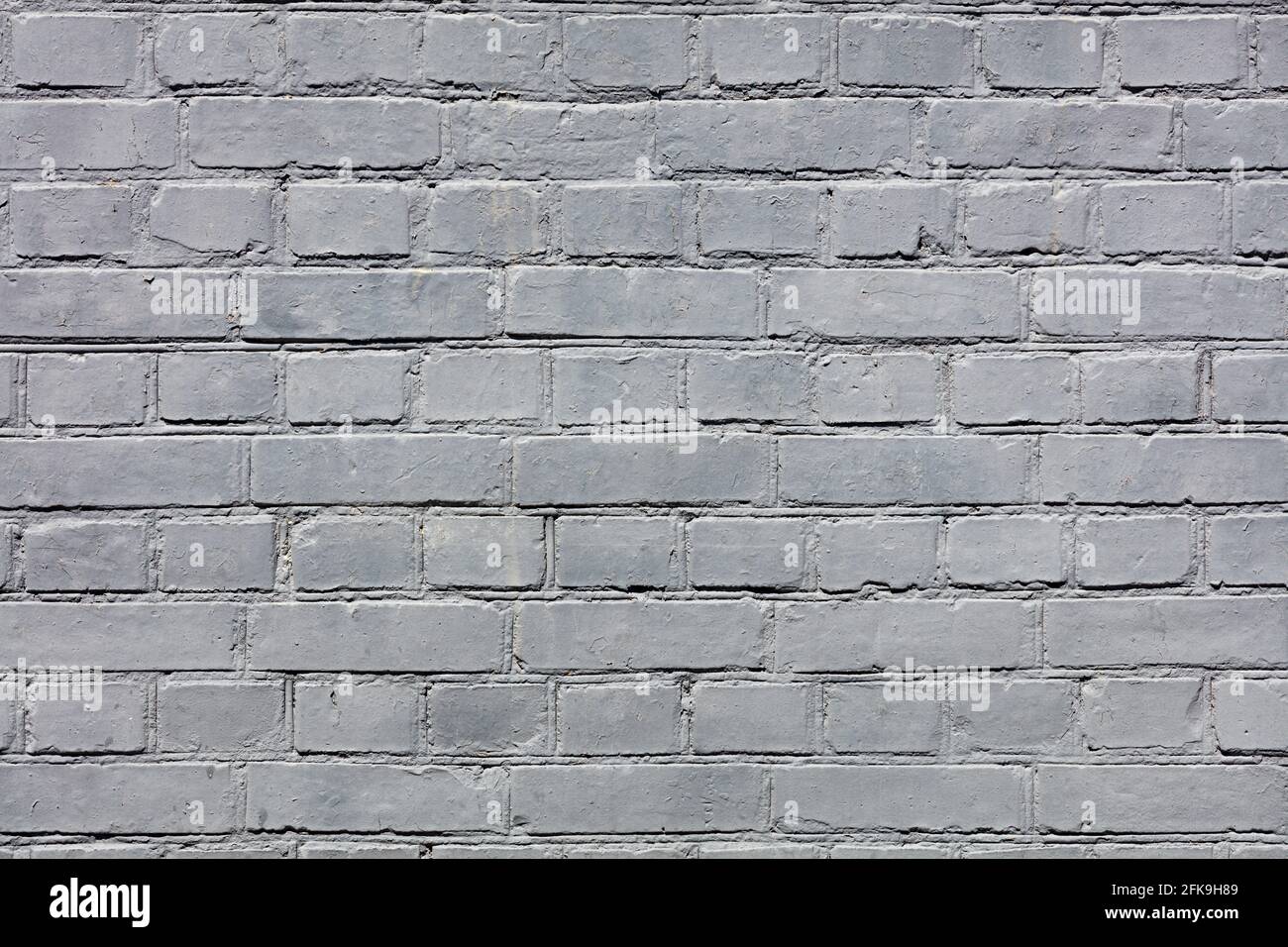 The bright texture of the old brick wall is completely painted with