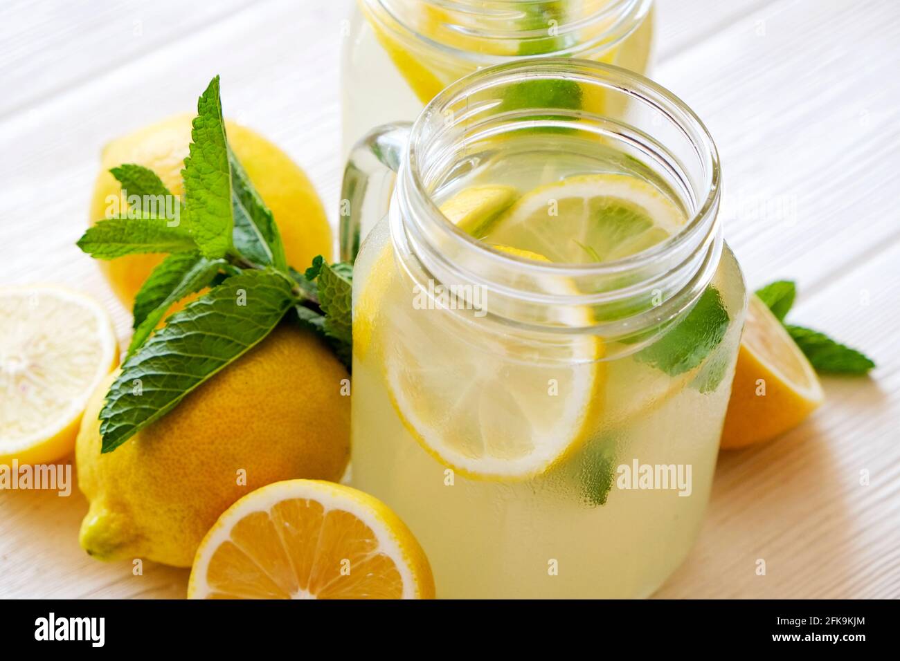 Two mason jar glasses of homemade refreshing lemonade with slices of ...