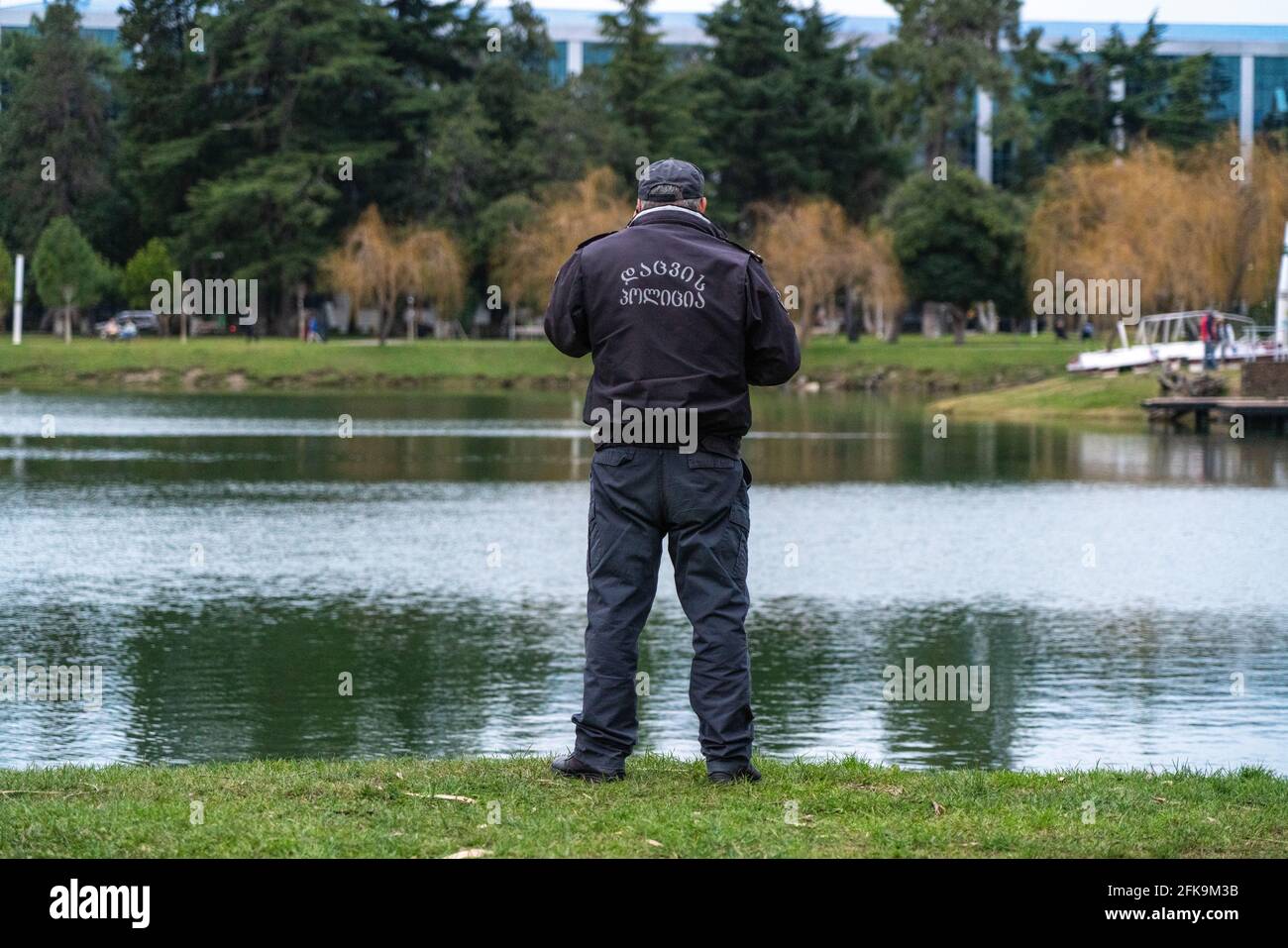policeman talking on the phone against the background of the lake Stock Photo