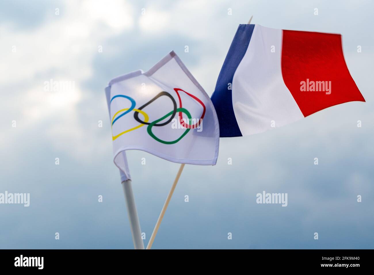 Fan waving the national flag of  France and the Olympic flag with symbol olympics rings. Stock Photo
