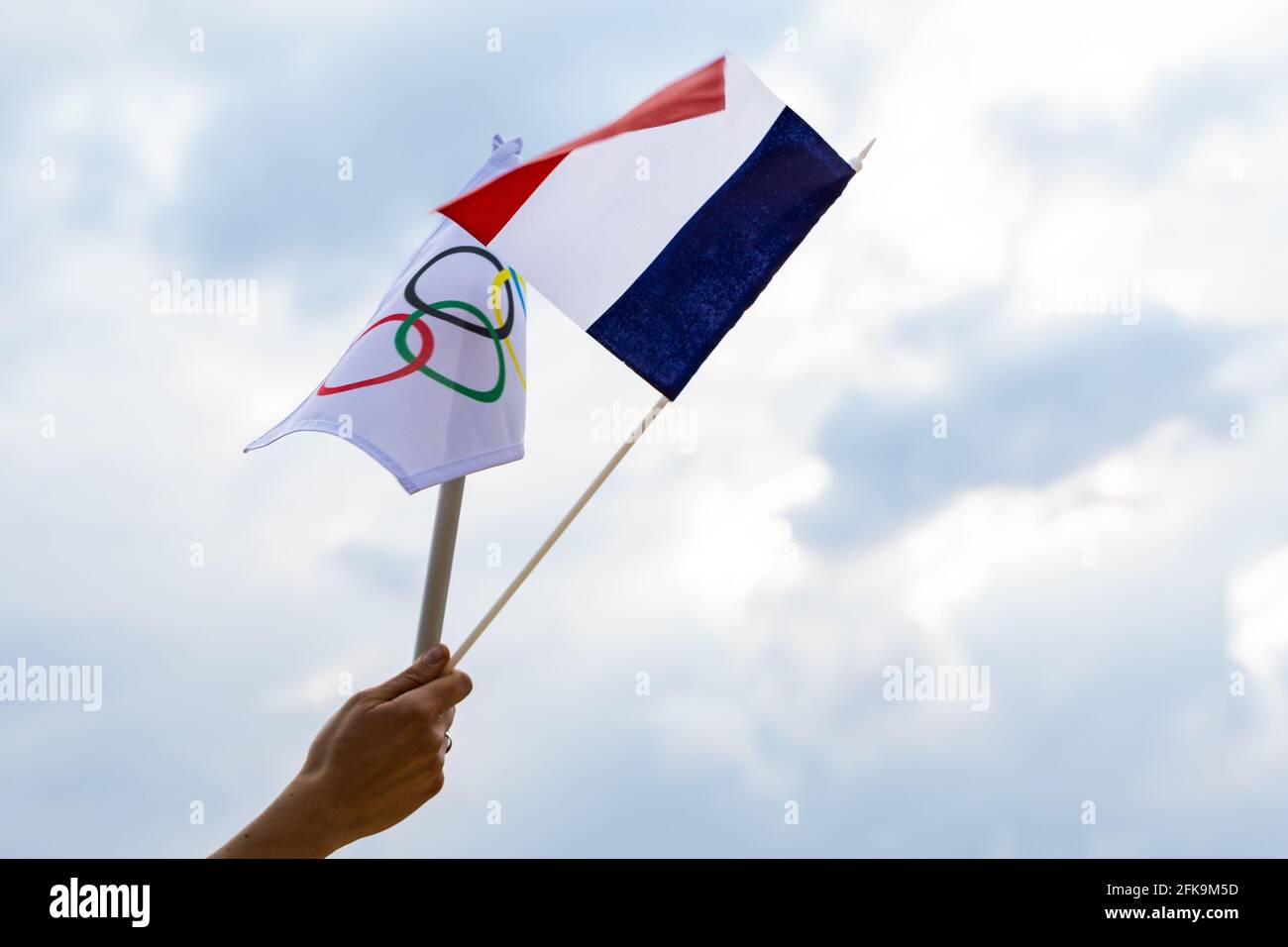 Fan waving the national flag of  France and the Olympic flag with symbol olympics rings. Stock Photo