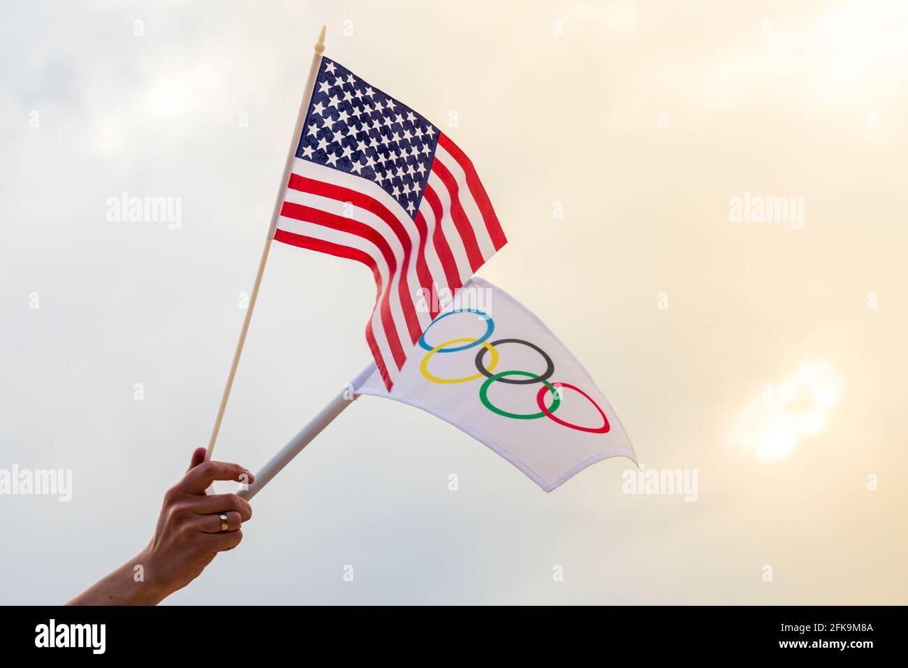 Fan waving the national flag of  USA and the Olympic flag with symbol olympics rings. Stock Photo