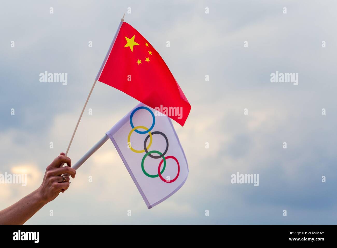 Fan waving the national flag of  China and the Olympic flag with symbol olympics rings. Stock Photo