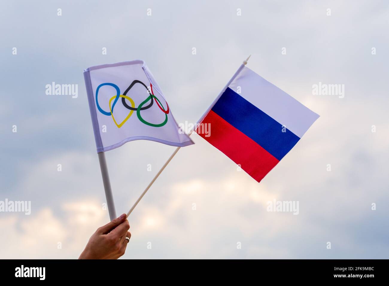 Fan waving the national flag of  Russia and the Olympic flag with symbol olympics rings. Stock Photo
