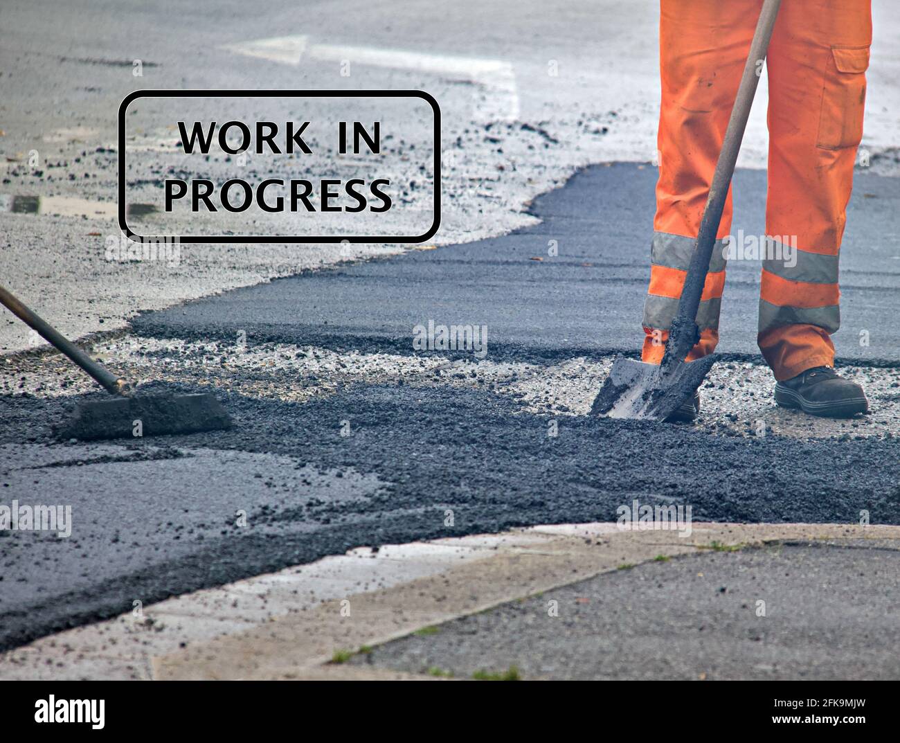Text "work in progress" with workers as background. Stock Photo