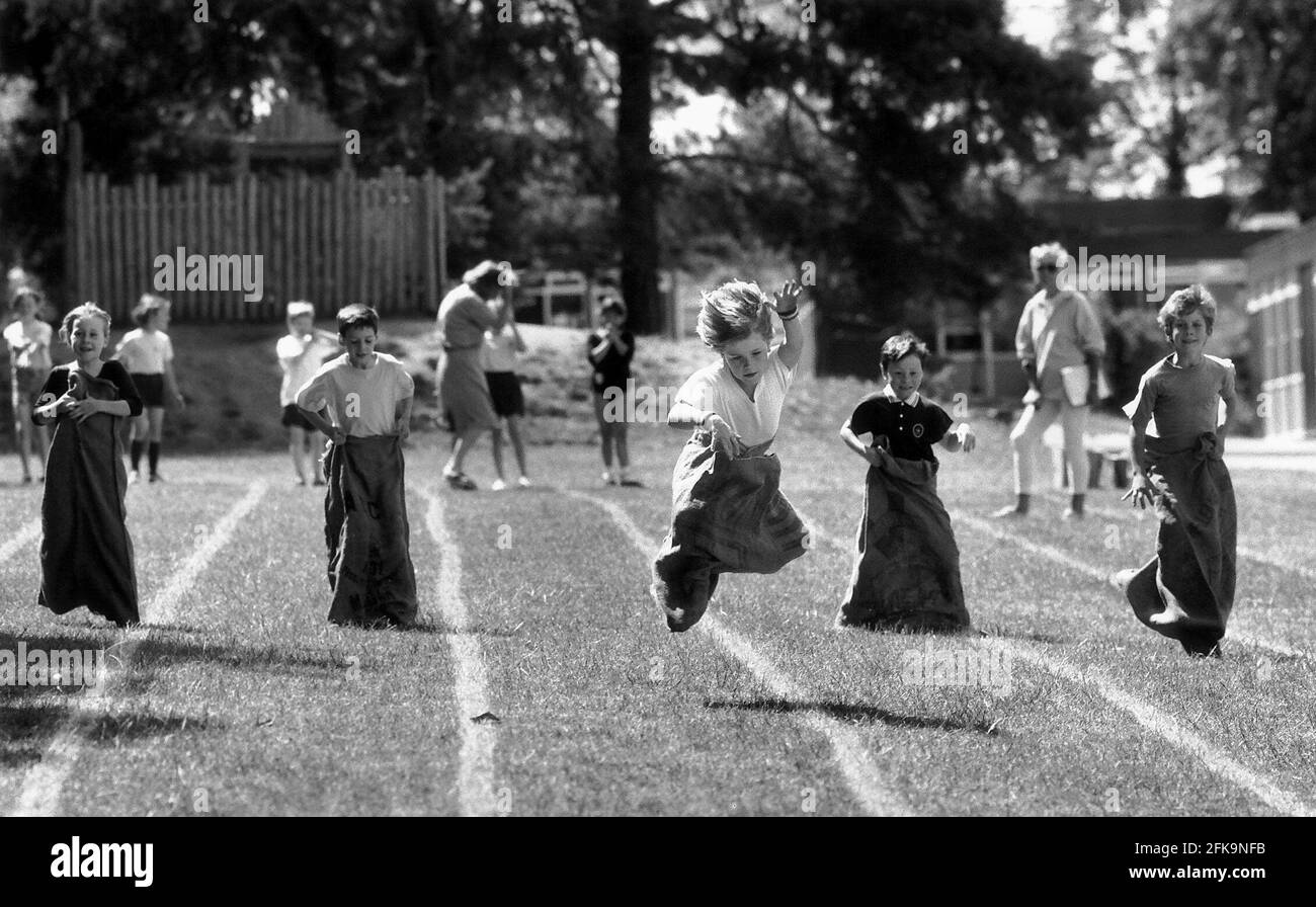 Boys compete in a sack race at an Infants School Children Sports Day at RAB Infants School in Saffron Walden Essex Dbase Stock Photo
