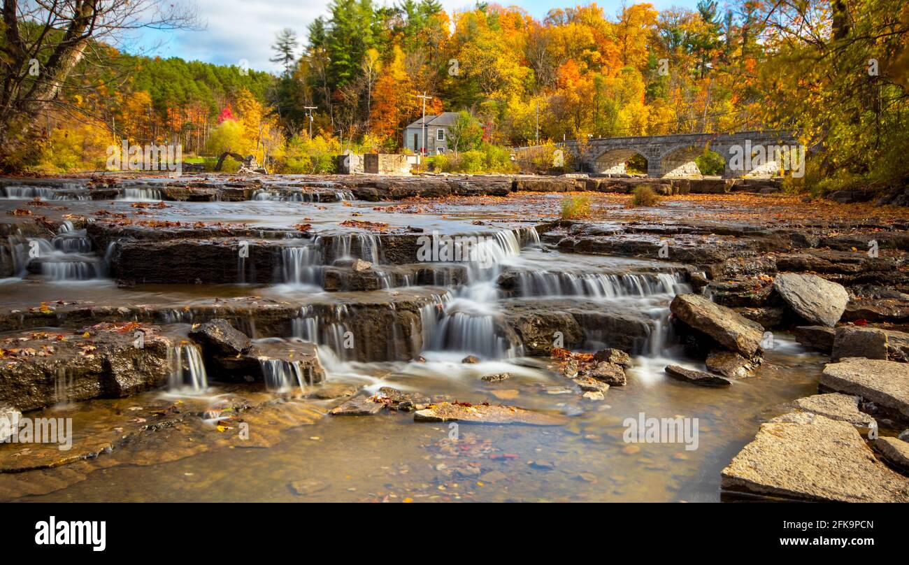 Waterfall in autumn with a scenic background. Backdrop of trees with