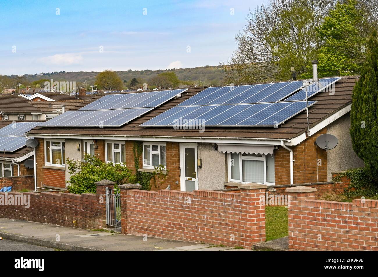 Bridgend, Wales - April 2021: Front exterior view of a pair of bungalows fitted with solar panels on the roof. Stock Photo