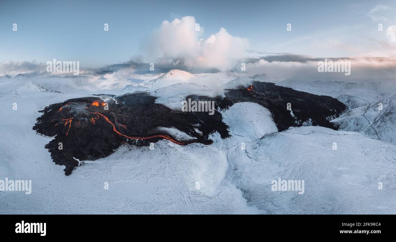 Aerial Panorama of active lava river flows from a volcanic eruption in mount Fagradalsfjall Geldingadalir valley, Southwest Iceland. Blue sky with Stock Photo