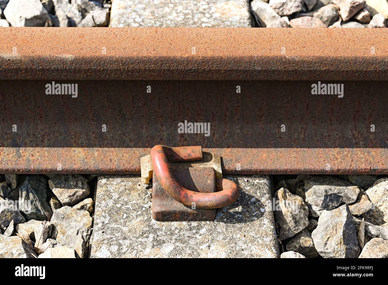 Close up view of a heavy metal clasp fixing a railway track to a