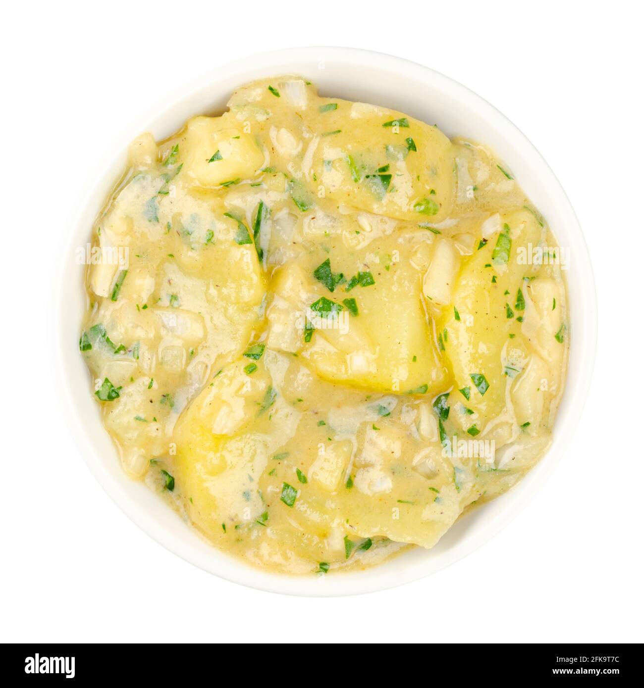 Potato salad with oil and vinegar in white bowl. Traditional German and Austrian side dish made from boiled potatoes, oil, vinegar, onion and parsley. Stock Photo