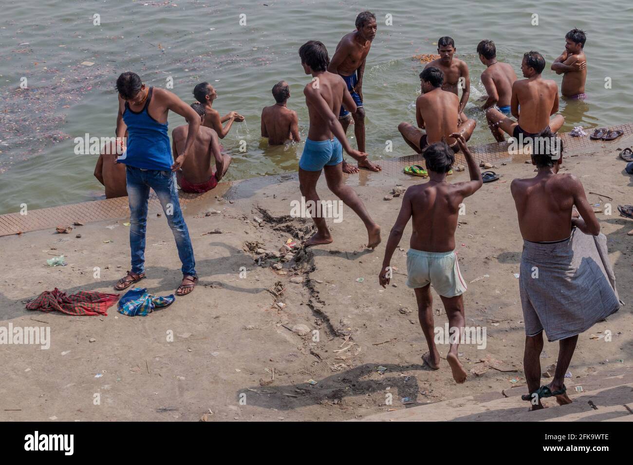 VARANASI, INDIA - OCTOBER 25, 2016: Local people wash themself in sacred water of Ganges rover at a Ghat riverfront steps in Varanasi, India Stock Photo