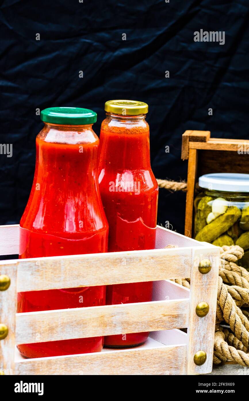 https://c8.alamy.com/comp/2FK9X69/bottles-of-tomato-sauce-preserved-canned-pickled-food-concept-isolated-in-a-rustic-composition-2FK9X69.jpg
