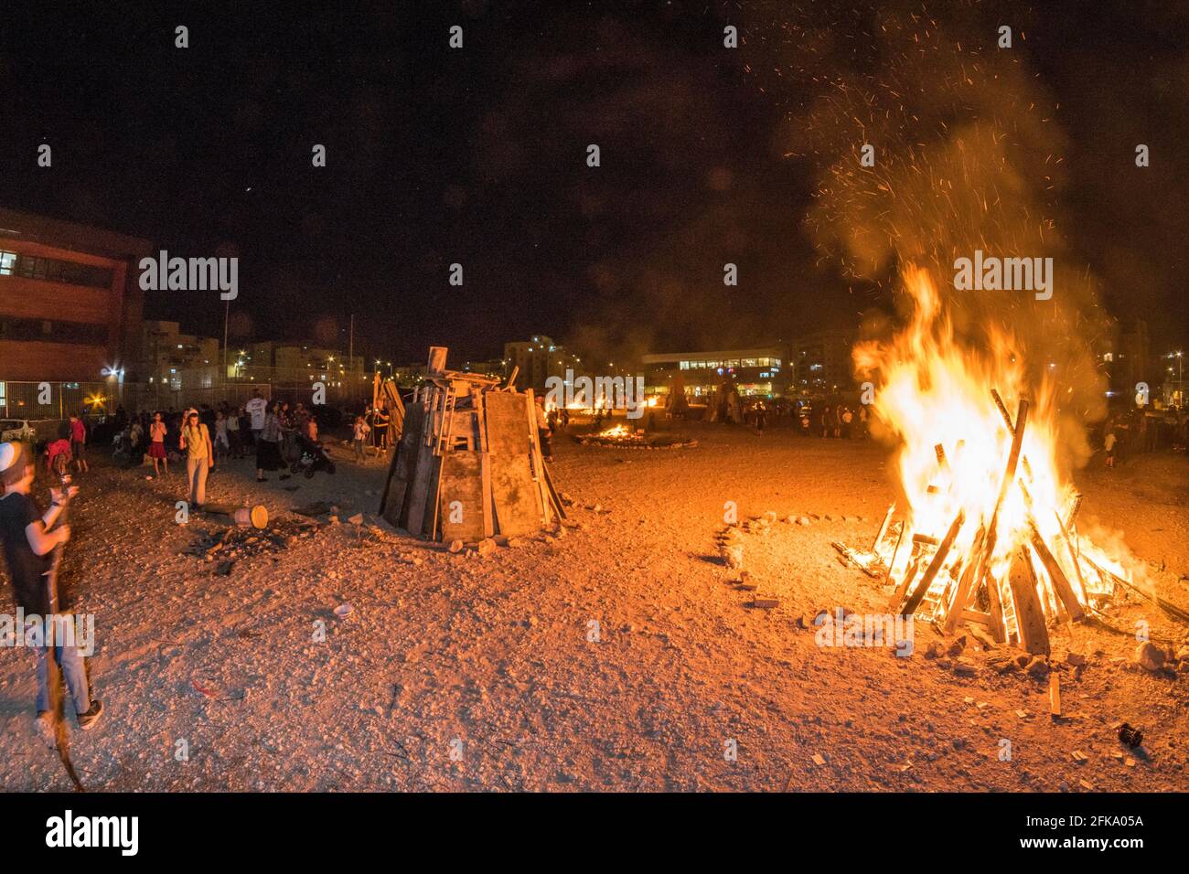People making fires during the Jewish Holiday of Lag Ba'Omer, which takes place every  18th of Hebrew month Iyar. It is customary during this holiday to make fires. This year, due to fire hazard warning, all fires were concentrated to few sites, hence the large number of pyres. Stock Photo