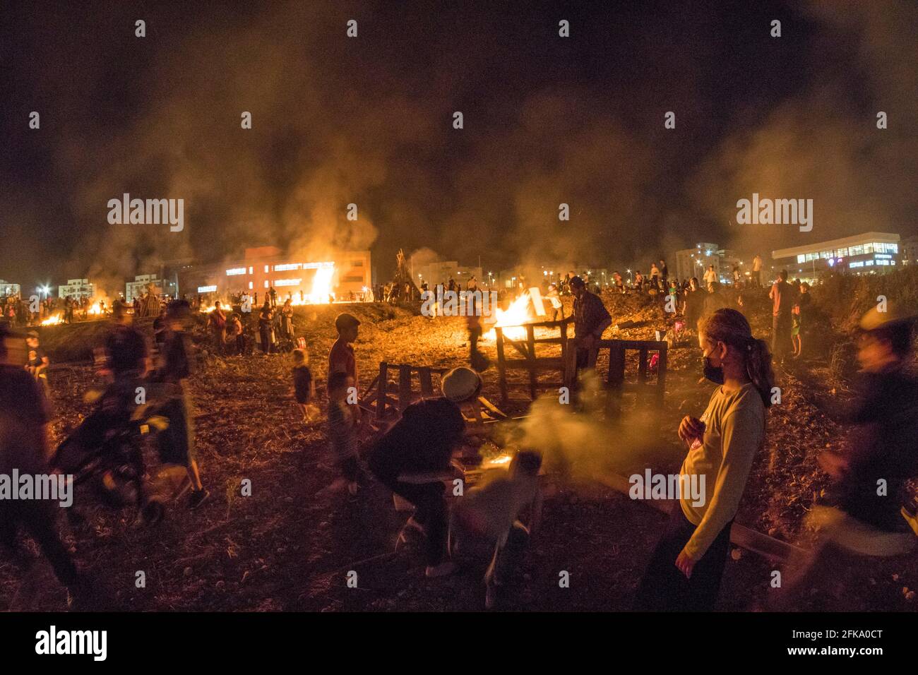 Children prepare a pyre during the Jewish Holiday of Lag Ba'Omer, which takes place every  18th of Hebrew month Iyar. It is customary during this holiday to make fires. This year, due to fire hazard warning, all fires were concentrated to few sites, hence the large number of pyres. Stock Photo
