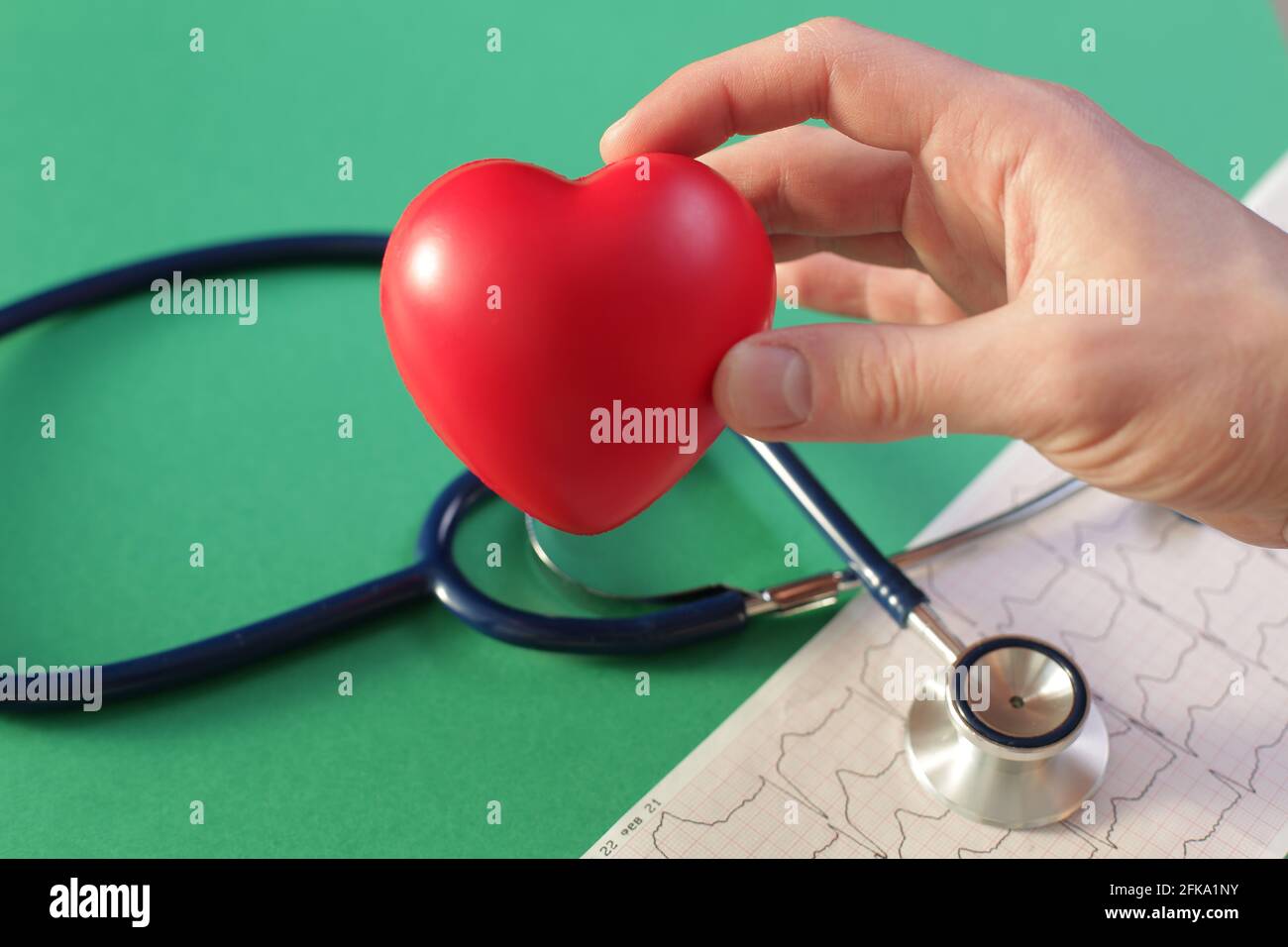 Doctor's hand with medical stethoscope heart and cardiogram on green ...