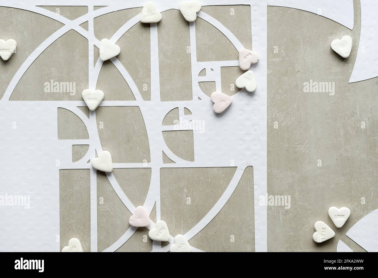 Fibonacci sequence circles and sugar hearts on beton stone background. Sweet taste perfection. Golden ratio concept. Top view, geometric paper art Stock Photo