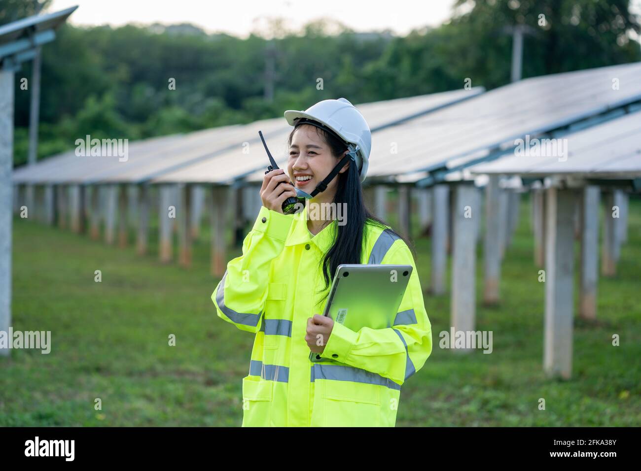 Engineer women wearing safety vest and safety helmet use radio Stock Photo