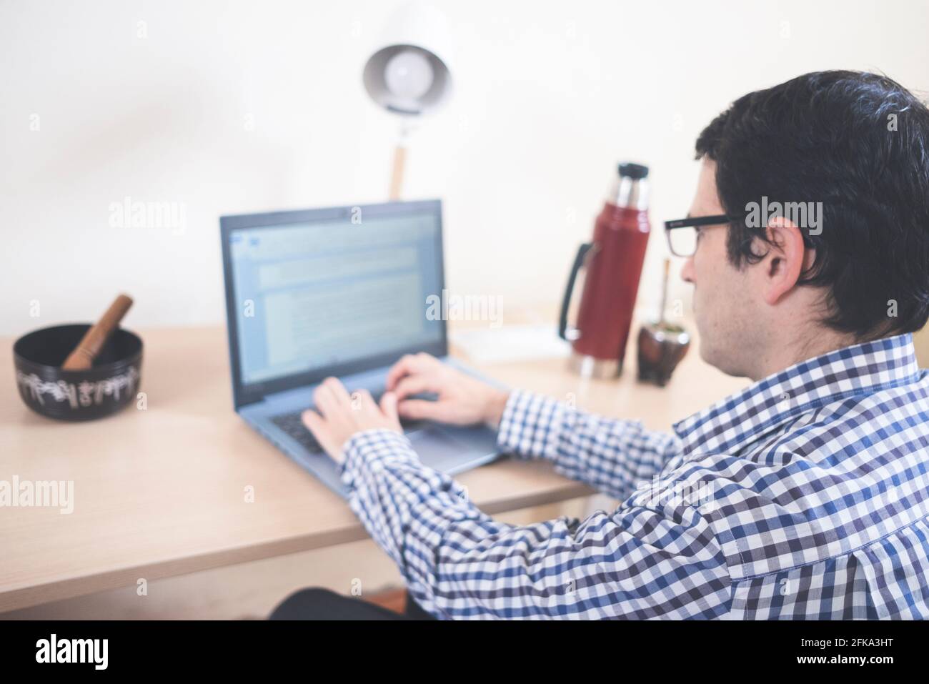 A man drinks mate while teleworking at home Stock Photo