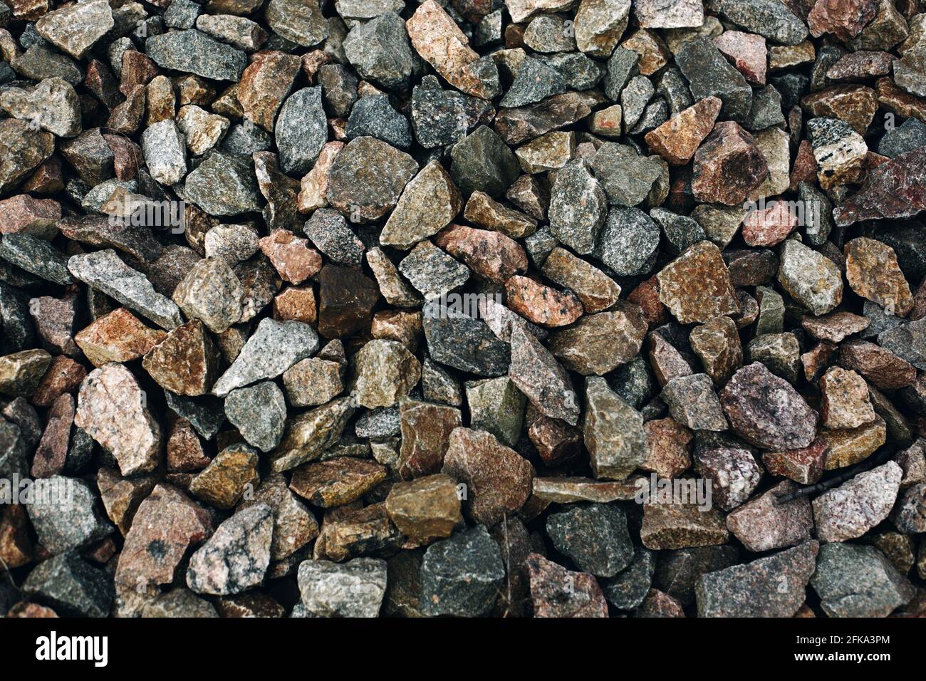 Old colorful stones rough background, many rocks near railway track Stock Photo