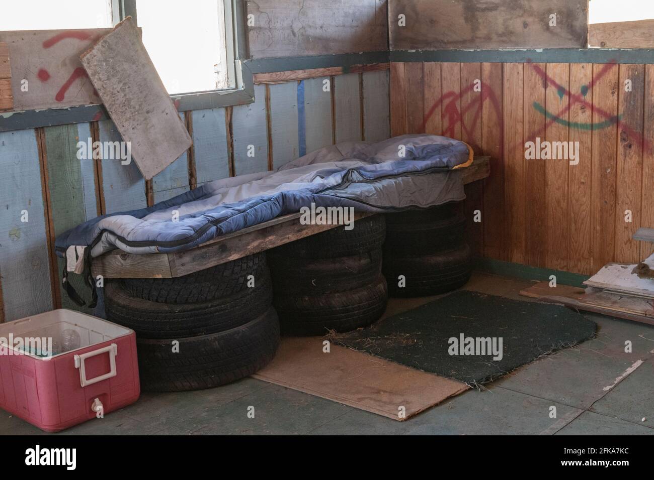 A homeless person has improvised a bed of tires and wood in an abandoned building in Klamath Falls, Oregon. Stock Photo