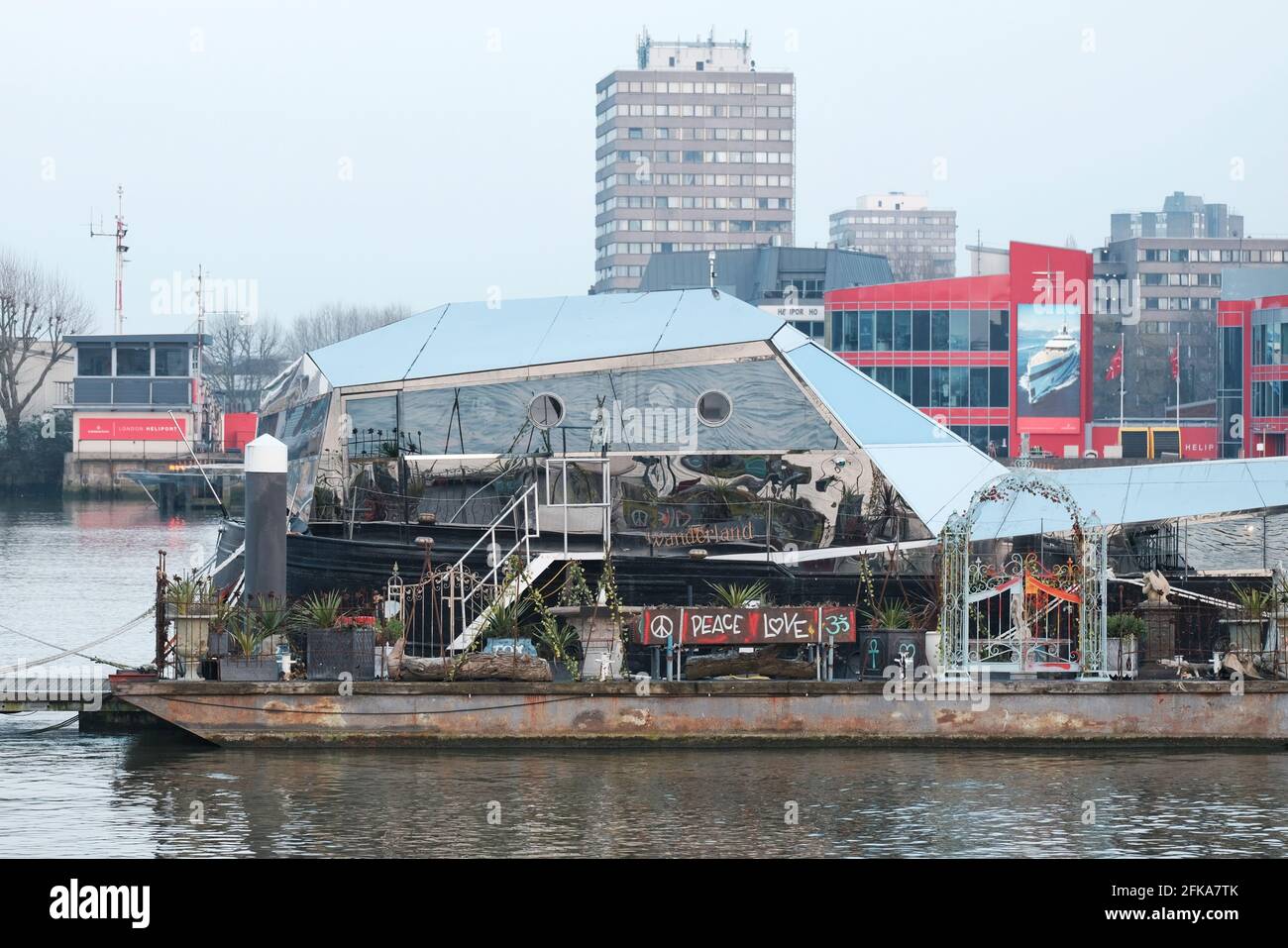 A floating garden is moored by houseboats on the River Thames by