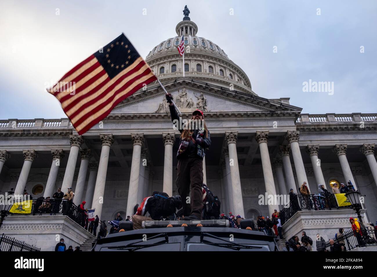 Washington DC, USA. 6th Jan, 2021. A man waves a flag in front of the Capitol Building during the storming of the building by Trump supporters. Stock Photo