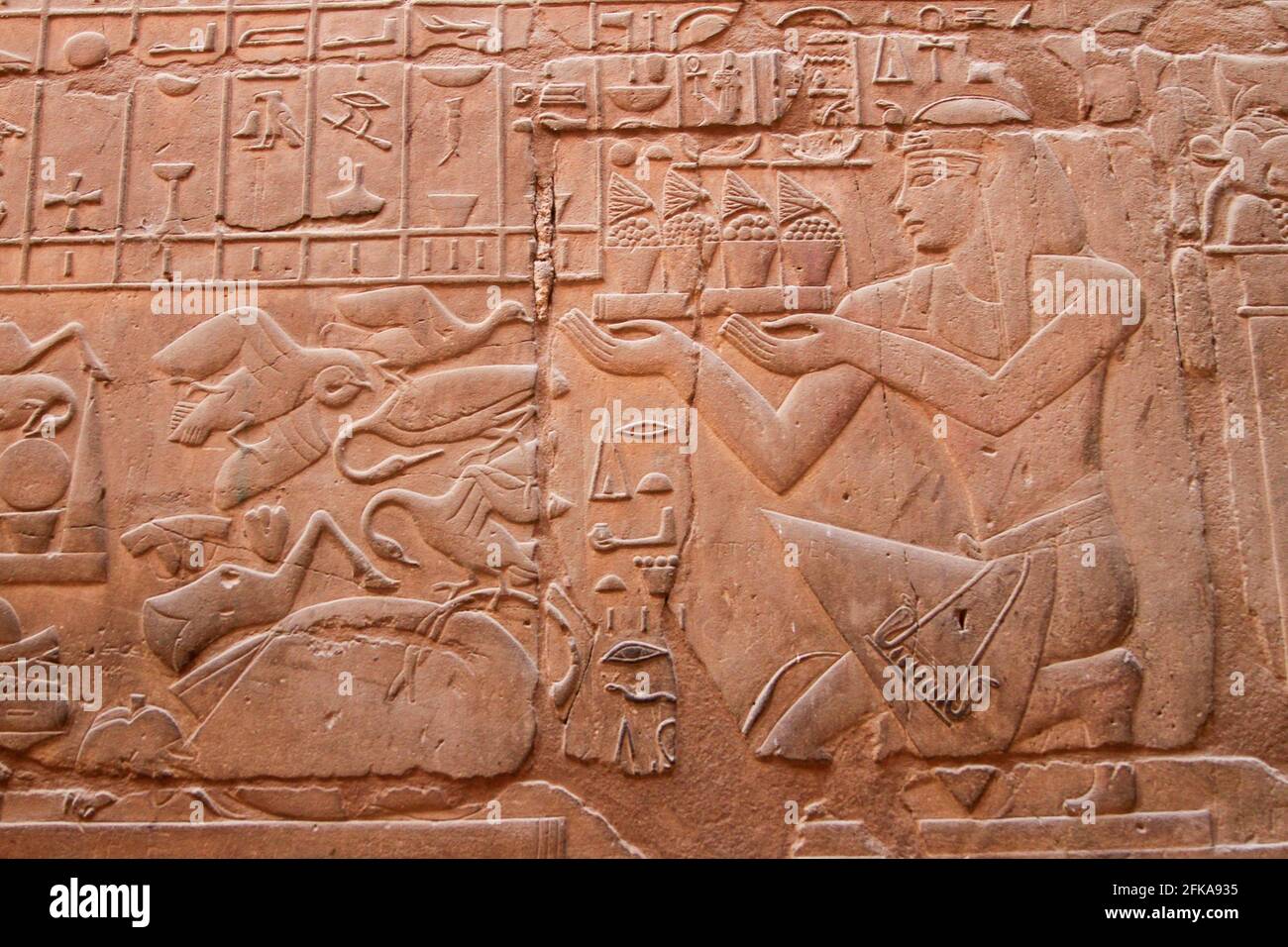 Carved sandstone relief of pharaoh and hieroglyphics on wall at Karnak Temple, Luxor, Egypt Stock Photo