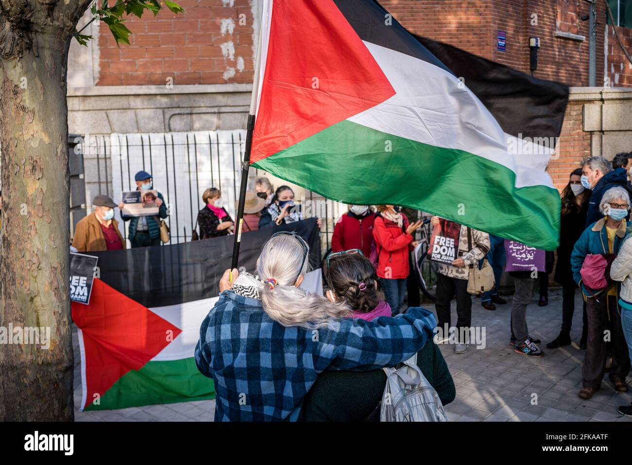 A protester holding the Palestinian flag in front of the Israeli embassy  during the demonstration. Dozens of people demonstrate in front of the  Israeli embassy while demanding the release of the Spanish