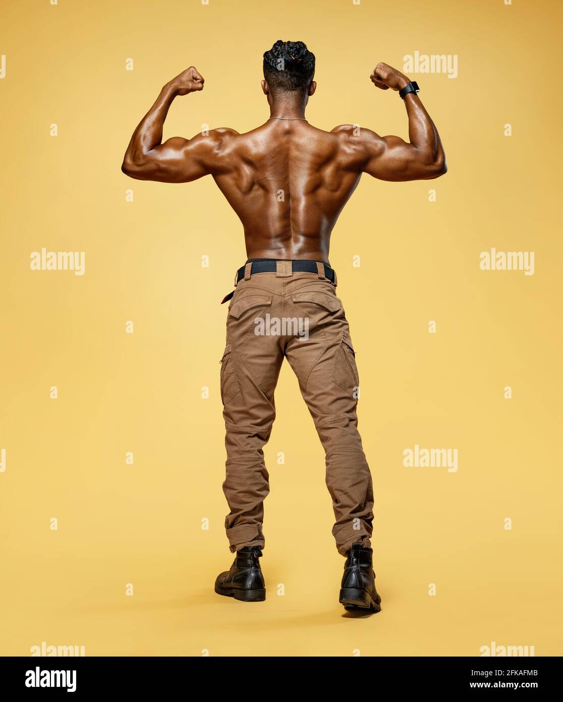 Young man showing his muscles. Rear view of bodybuilder with perfect ...