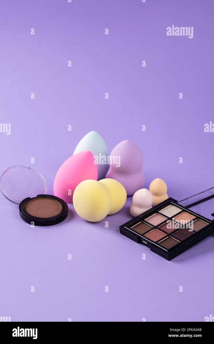 different colors of beauty blender, blush and eyeshadow Stock Photo