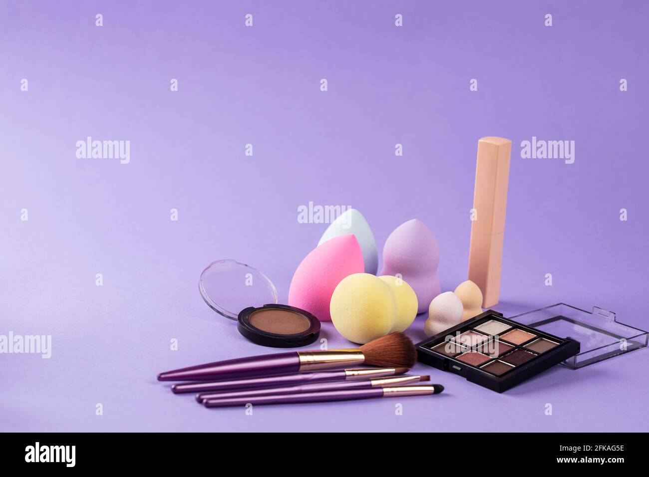 different colors of beauty blender, blush, eyeshadow and make up brushes Stock Photo