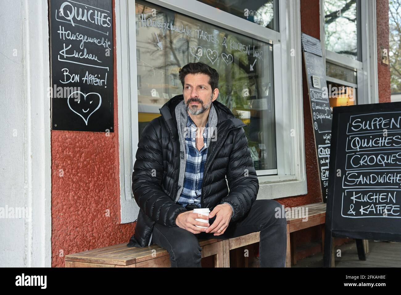 Berlin, Germany. 26th Apr, 2021. The Swiss film actor and musician Pasquale Aleardi sits on a walk in his neighborhood in Mitte at the Weinbergspark with a coffee in front of a French cafe. He is best known as Inspector Dupin in the ARD crime series of the same name, which is set in Brittany. The next case 'Kommissar Dupin - Bretonische Spezialitäten' can be seen on May 6 at 8:15 p.m. on the German TV channel Ersten. Credit: Jens Kalaene/dpa-Zentralbild/ZB/dpa/Alamy Live News Stock Photo