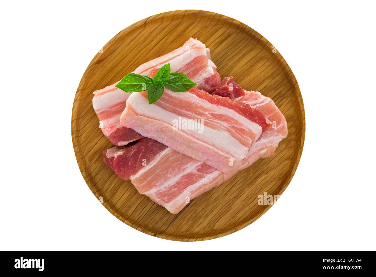 Slices of raw fresh pork belly cut on wooden plate isolated on white background Stock Photo