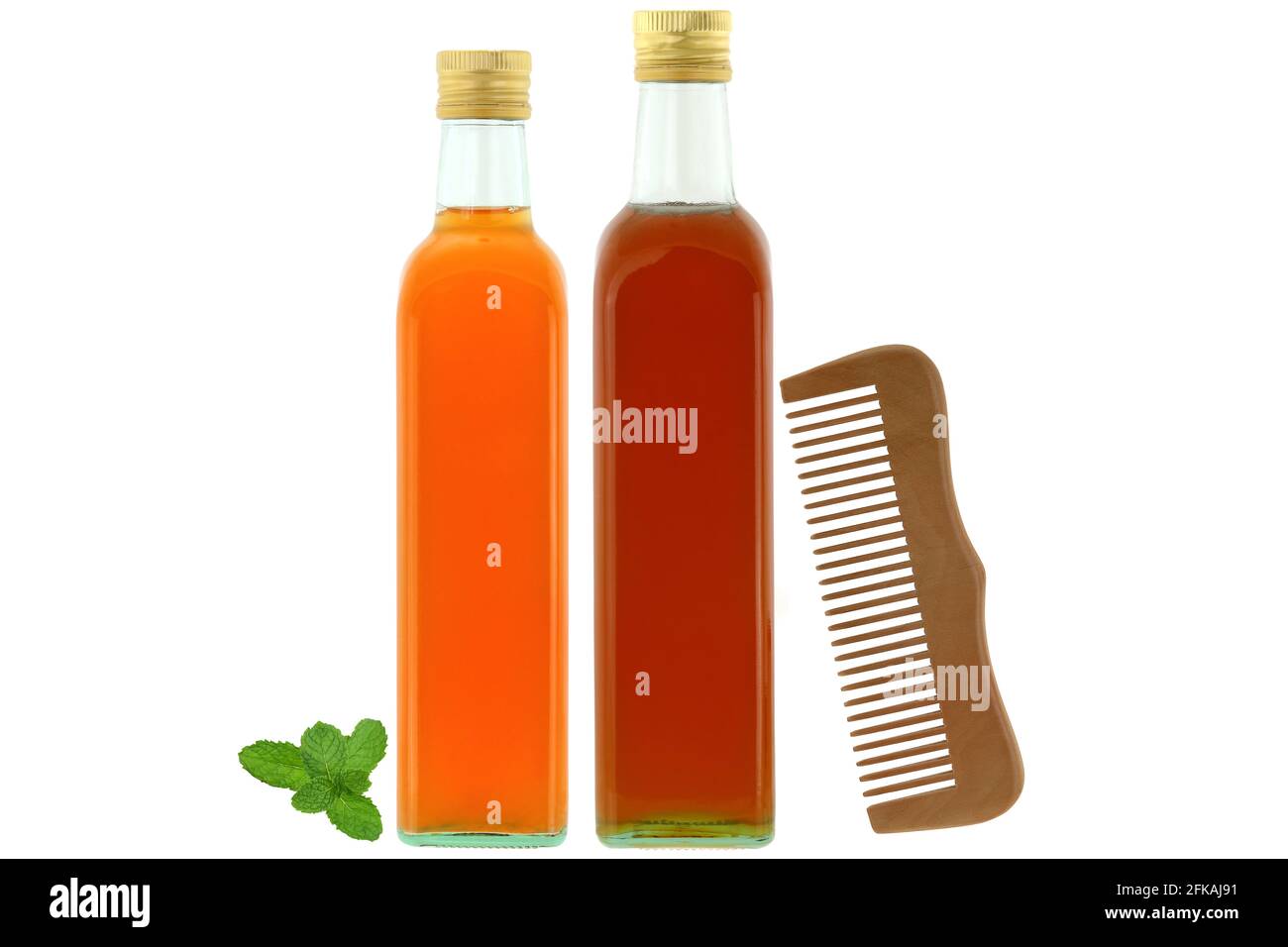 Bottles of raw and unfiltered organic apple cider vinegar with mother enzymes, organic honey next to wooden comb, ingredients for dry and damaged hair Stock Photo