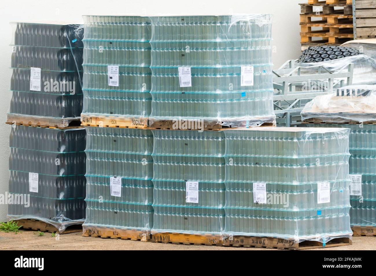 glass wine bottles wrapped in plastic and stacked up outdoors concept