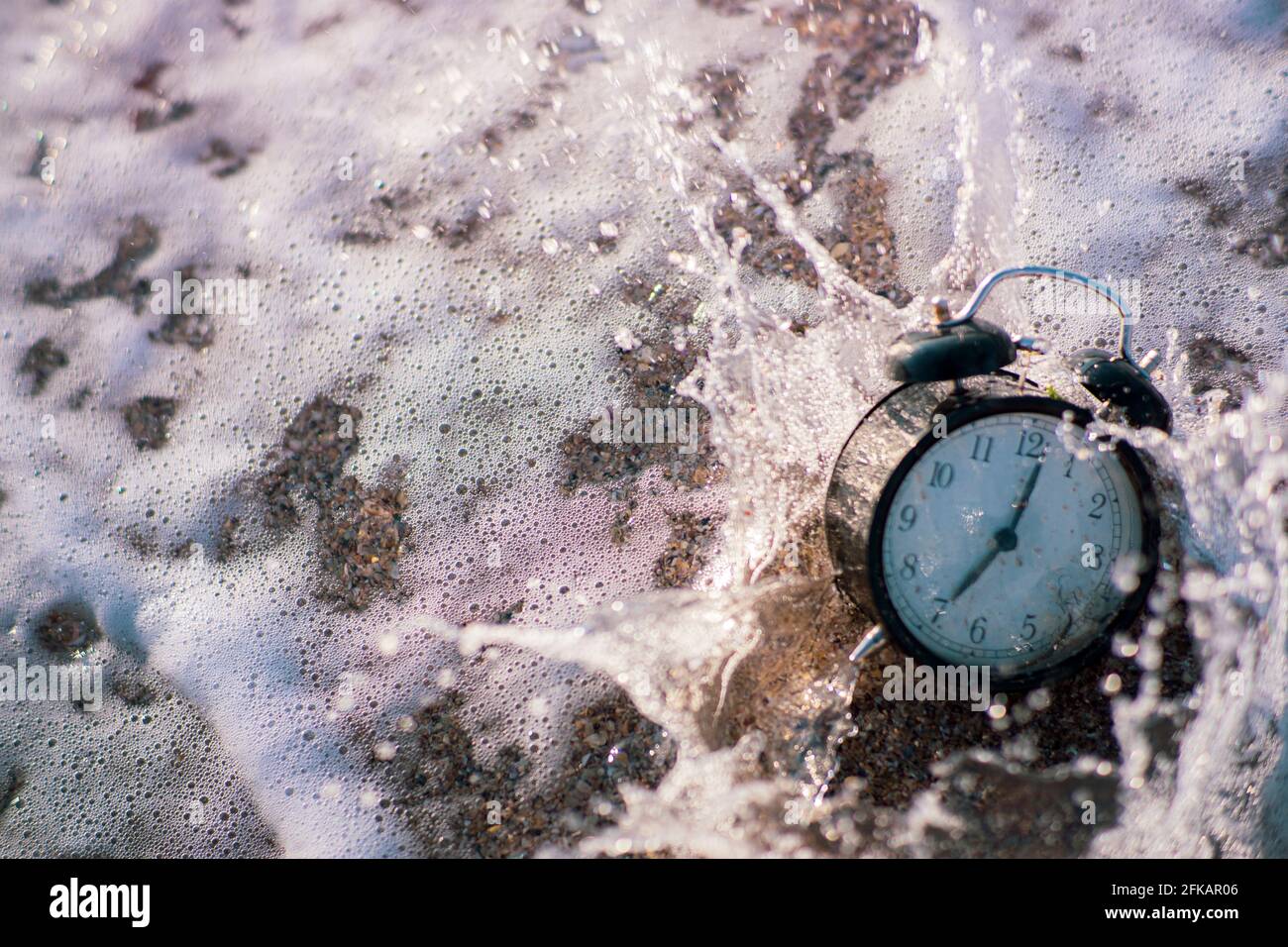Alarm clock splashing in the beach water Stock Photo Alamy