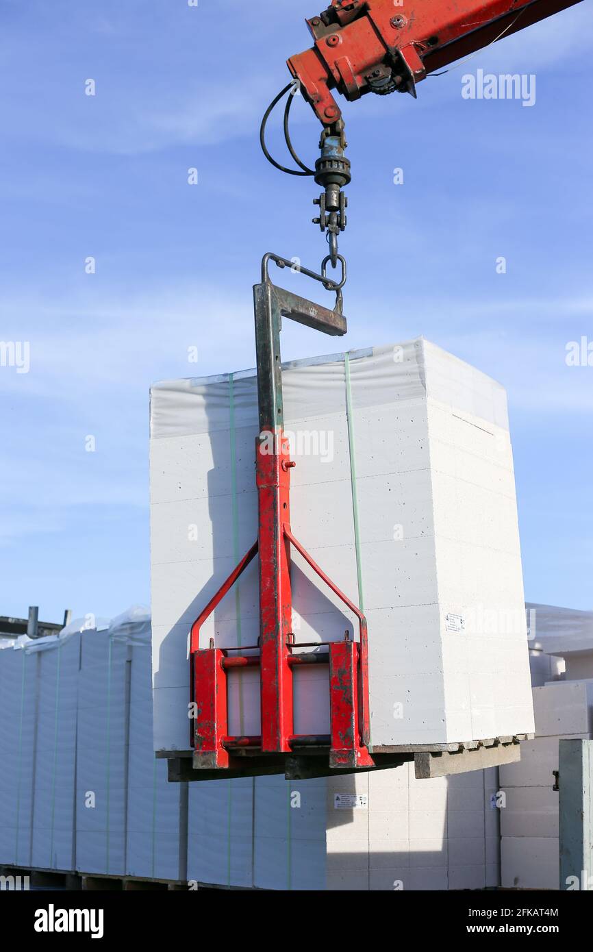 Unloading building blocks from a truck using a crane. Hydraulic ...
